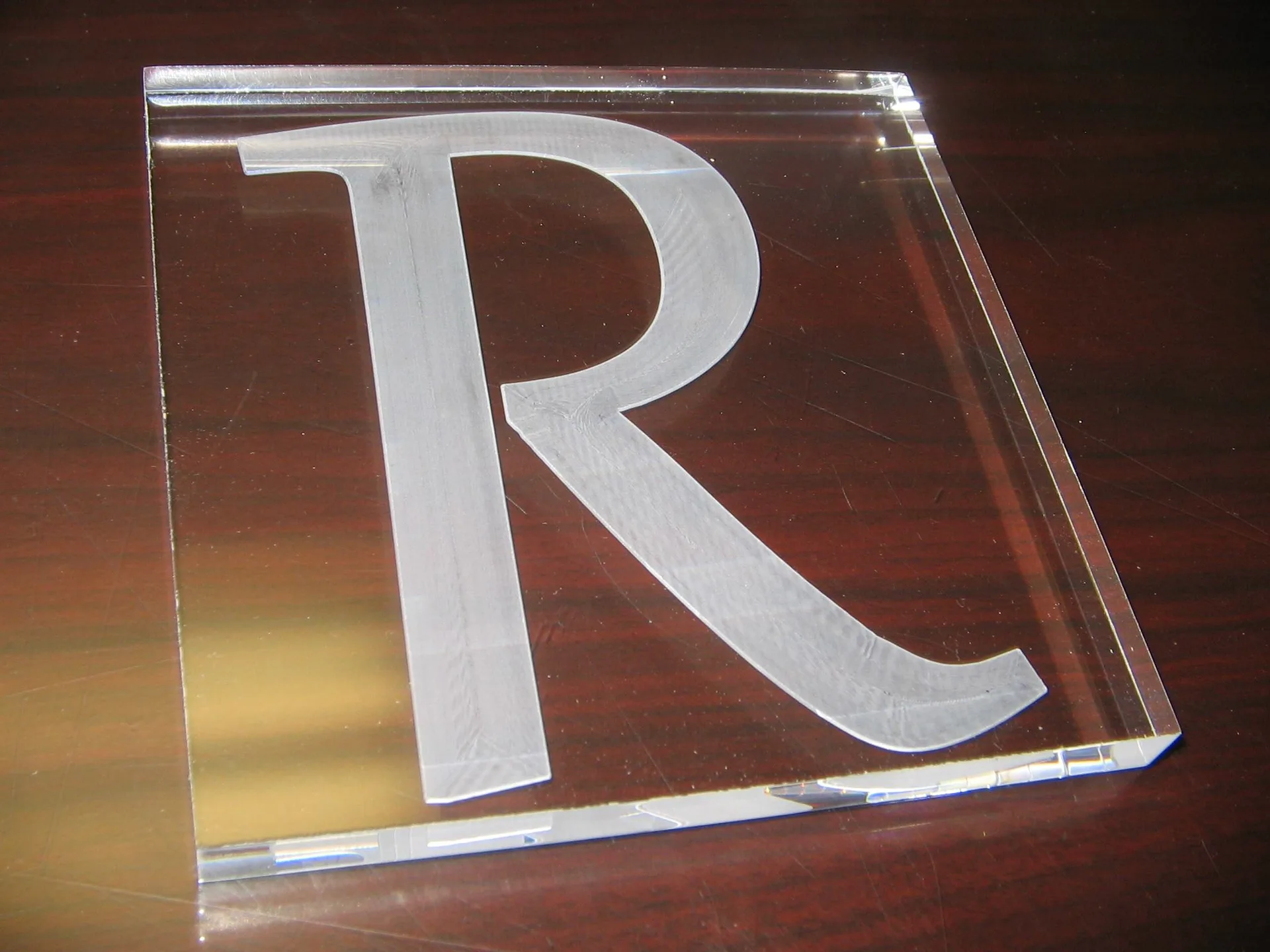 Laser engraved wood plaque, acrylic keychain, metal tag, and leather patch