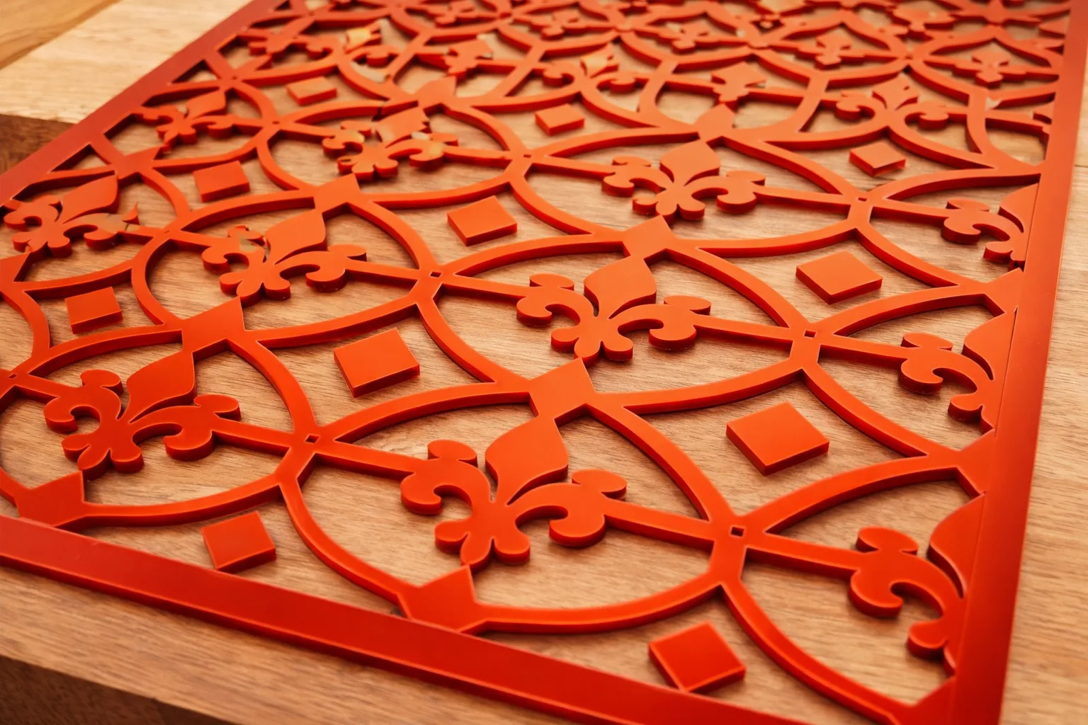 Intricate red laser cut decorative panel on wood