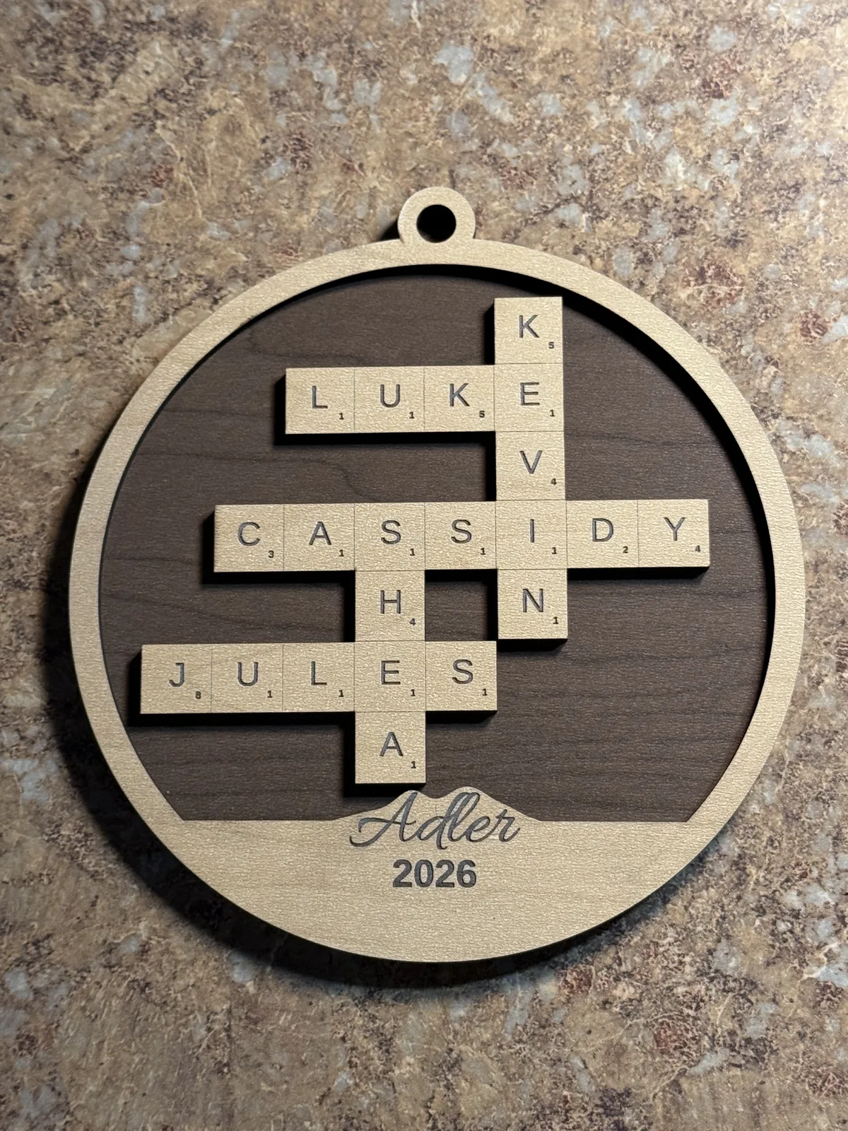 Finished personalized Family Crossword Ornament with a dark wood-grain backer